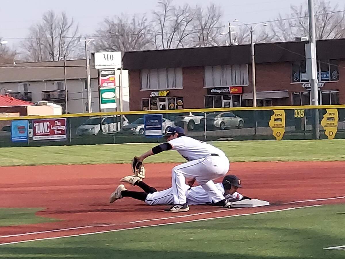 Highland’s Tyler Griesbaum slides back into first base ahead of the tag of O’Fallon first baseman Corey Quintal during a non-conference game Tuesday, March 29, at Blazier Field in O’Fallon. The Panthers edged the Bulldogs 4-3 in eight innings.