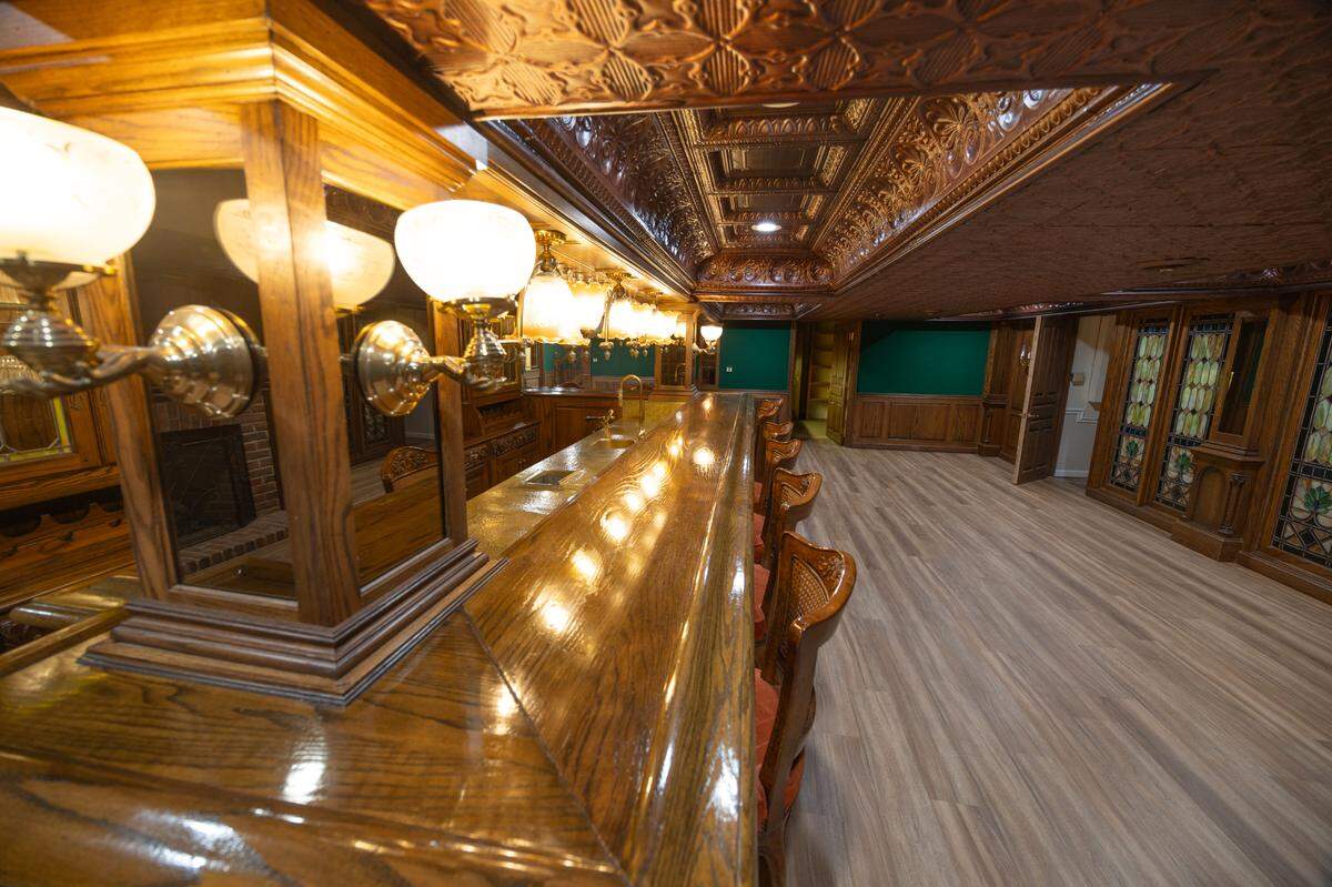The bar in the basement features hundreds of square feet of hardwood fixtures and dozens of elegant art deco lights.