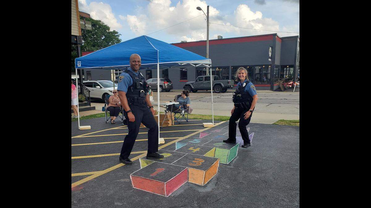 Chalk It Up grand prize winner Maria Knecht drew a 3D hopscotch grid in the inaugural year 2021. Shown here are former O'Fallon police officer Bryan Lemons and detective Kathy Effan. 