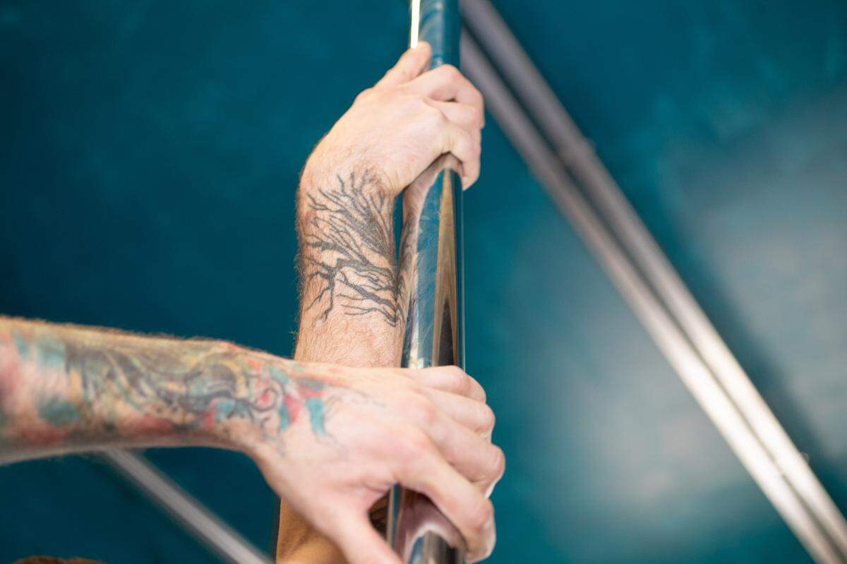 Brian Lynch puts his hand along a pole used for dancing and aerobics in his new Belleville, Ill., studio, Valkyrie Aerial Arts.