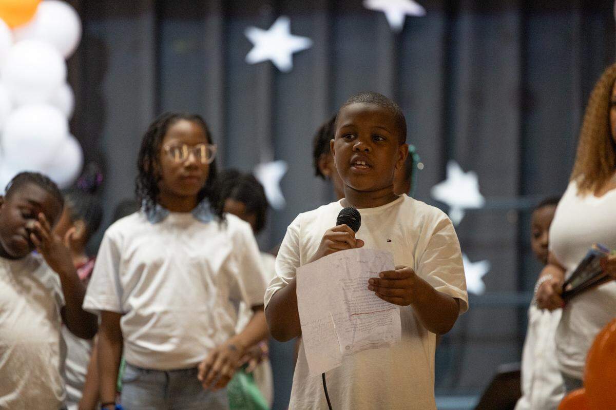 Elementary schoolers sing “Boots on the Ground” in front of a crowd of cheering parents during 2025’s annual “Spring Family Forum,” a showcase for East St. Louis School District 189’s After School 21st Century Programs. Five of these programs may close at the end of June 2025 should another funding source not be secured.