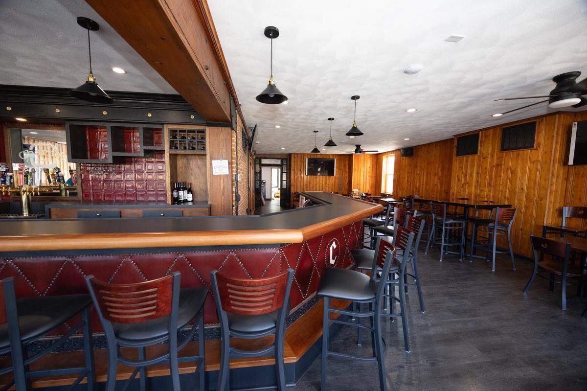 Owners of Charlie’s Place in Belleville kept its knotty-pine paneling, exposed brick wall and classic L-shaped bar that’s trimmed in mahogany and upholstered in burgundy leather with brass tacks.