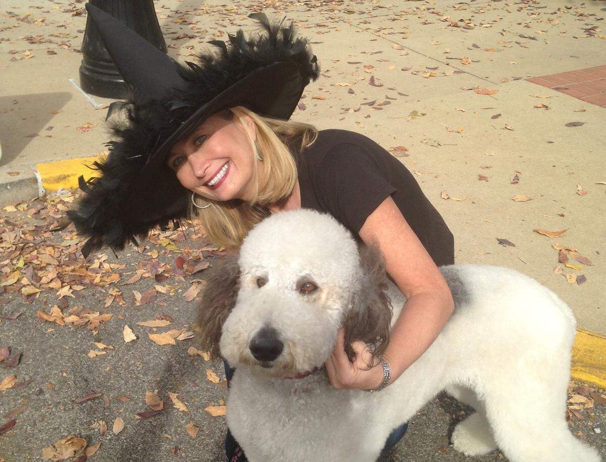 Michelle Schrader poses with Vegas, a standard poodle and previous parade costume contest winner. The dog is owned by Mikey Velazquez of Belleville.