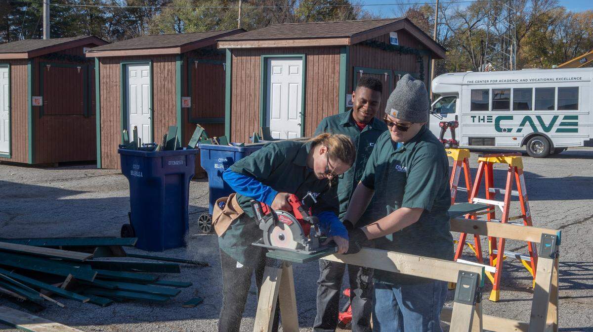 Cailyn Galloway, Mark Lash, Michael Porter and other students from the construction class at Belleville High School District 201’s Center for Academic and Vocational Excellence (The CAVE), joined forces with Home Depot and the City of Belleville Public Works Department to assist in repairing the Belleville Christkindlmarkt Chalets. The chalets have been used for 9 years and needed a variety of repairs. The 9th annual Belleville Christkindlmarkt opens Friday November 25th at 9 am on the public square in Downtown Belleville with 30 vendors. For more information and a detailed schedule visit www.bellevillechristkindlmarkt.com