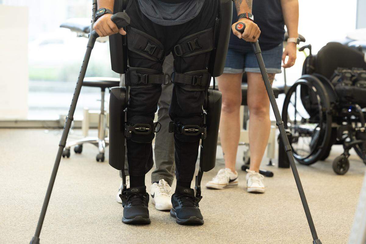 Brad Henke stands using his new exoskeleton during physical therapy. Training for his new legs takes much endurance and diligence and requires frequent visits to become accustomed to the new change.