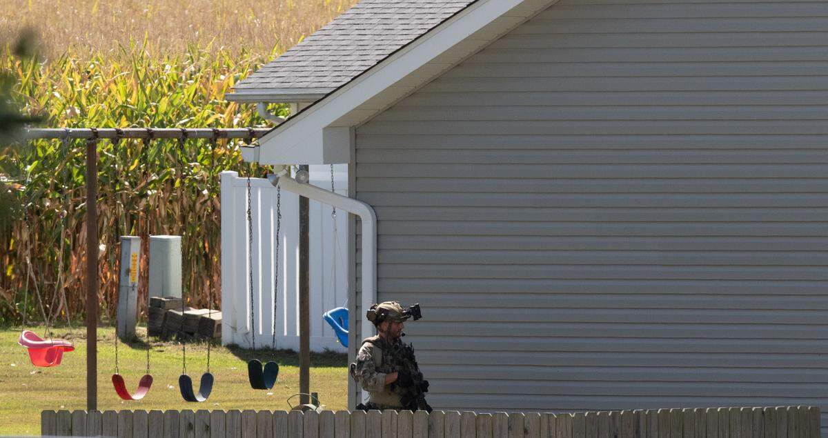 A SWAT officer patrols the home of a suspect during a standoff in the 1800 block of Meadow Court in Columbia, Ill.