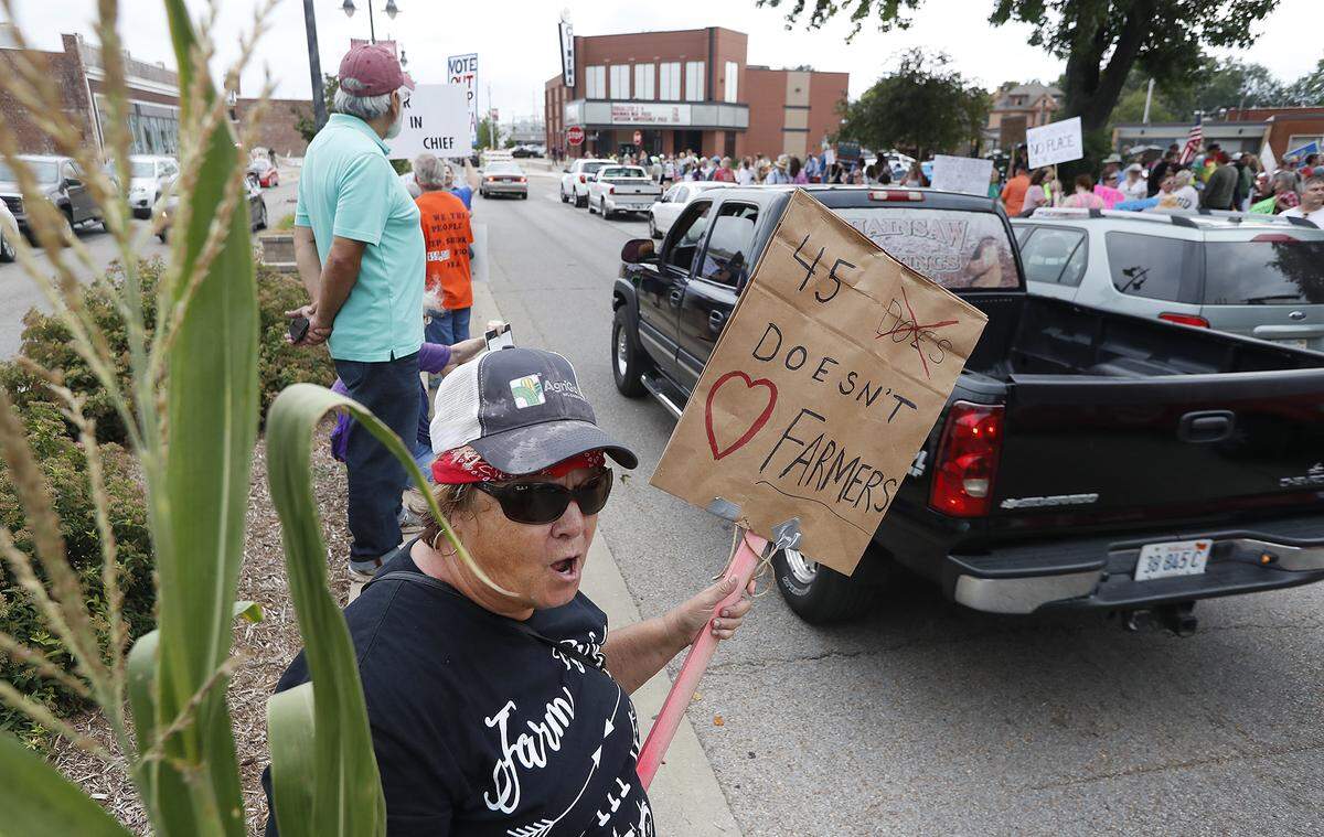 Paula Shelton holds a stalk of corn from her farm as she chants along with anti-Trump protestors Thursday in downtown Granite City. Shelton is against the new trade tariffs and has a farm where she lives in Donnellson. The corn stalk she brought with her has three ears of corn on it. She joked her husband would be mad at her for the loss of a fraction of a penny from the farm’s yield.