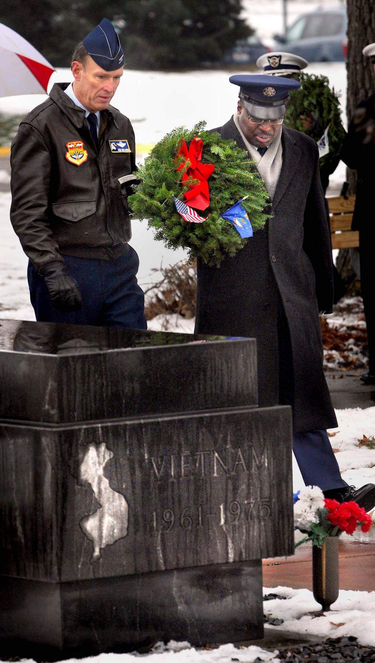 Bob Hillmer, left, and Kirk Darling, U.S. Air Force veterans, place a wreath on the Korean and Vietnam War memorial at Miller Park in Bloomington, Illinois, during a Wreathes Across America Ceremony, Dec. 11, 2010. The event is held concurrently with wreathes laid at Arlington National Cemetery marking U.S. soldiers, airmen, sailors and Coast Guardsmen that have died or are missing in the line of duty. The local event is sponsored by State Farm’s Military Affinity Group.