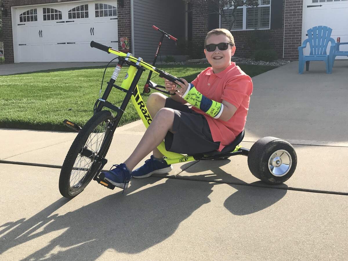 Andy Ord, 13, sits on his Razor tricycle in front of his O'Fallon home, which is one way he tries to stay active nearly everyday after school.