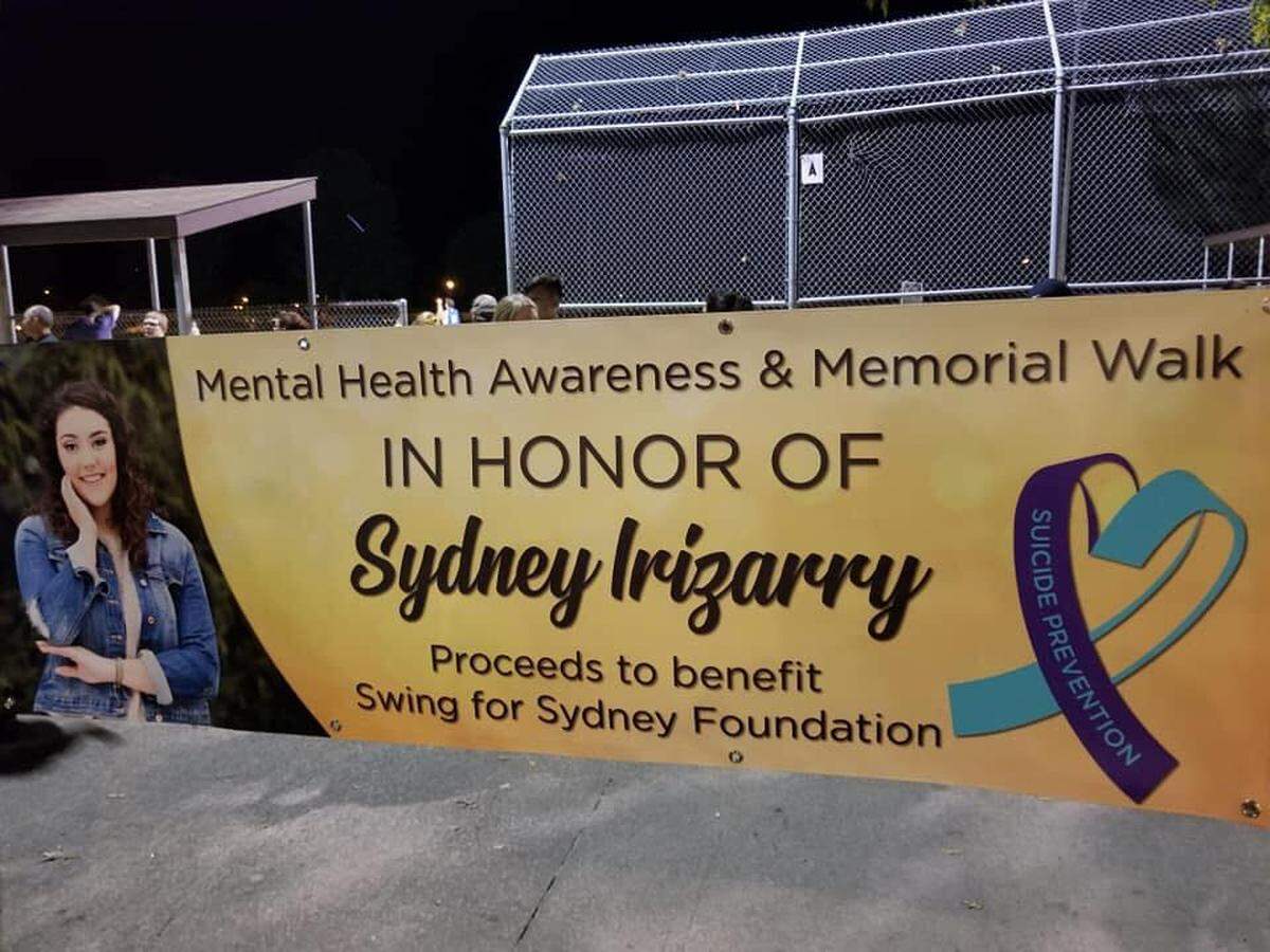 A banner with the late Sydney Irizarry’s photo is displayed on a fence during a fundraising walk for the Swing for Sydney Foundation in 2018.