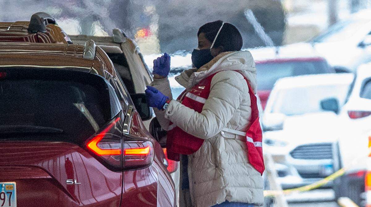 A worker speaks with someone getting a COVID-19 vaccination at Belle-Clair Fairgrounds in Belleville on Monday, the first day for a drive-thru clinic operated by St. Clair County agencies with help from the National Guard.