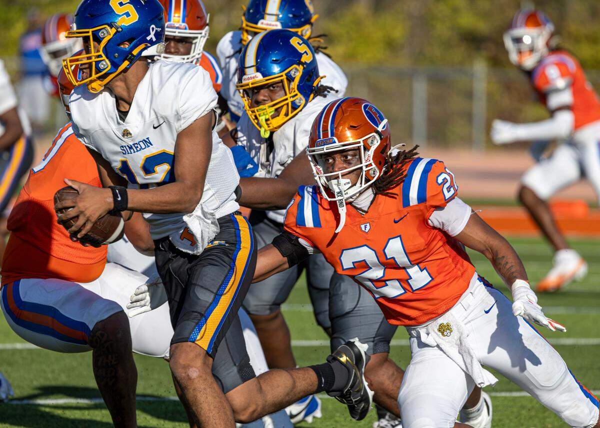 East St. Louis junior linebacker James Bryant closes in on Chicago Simeon quarterback Anthony Croom Jr. during the IHSA Class 6A football quarterfinal Saturday.