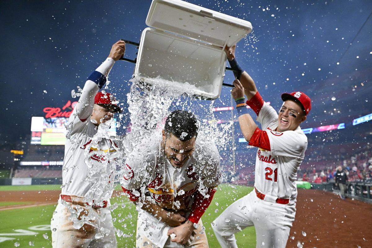 Aug 21, 2024; St. Louis, Missouri, USA;  St. Louis Cardinals third baseman Nolan Arenado (28) is doused with water by shortstop Masyn Winn (0) and center fielder Lars Nootbaar (21) after hitting a walk-off grand slam against the Milwaukee Brewers during the tenth inning at Busch Stadium. Mandatory Credit: Jeff Curry-USA TODAY Sports