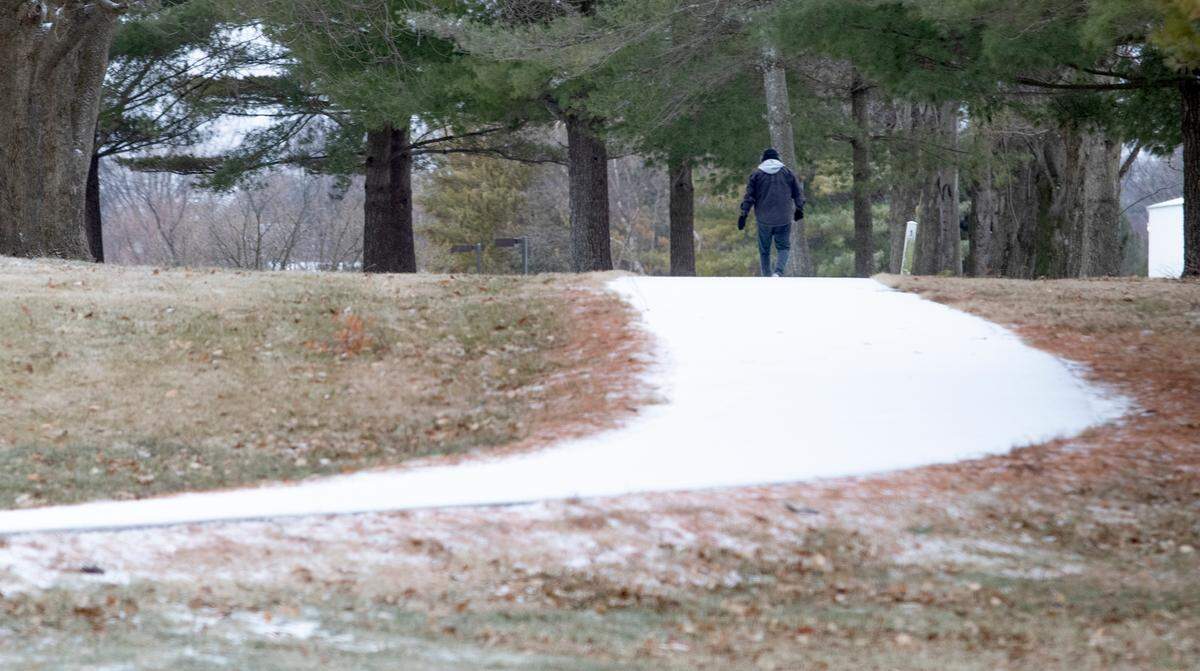 A person walks a sleet covered trail at Everett Moody Park in Fairview Heights, Illinois. Overnight a mix of sleet, ice and snow hit the St. Louis region coating roads, cars and walkways with a layer of wintry mix.