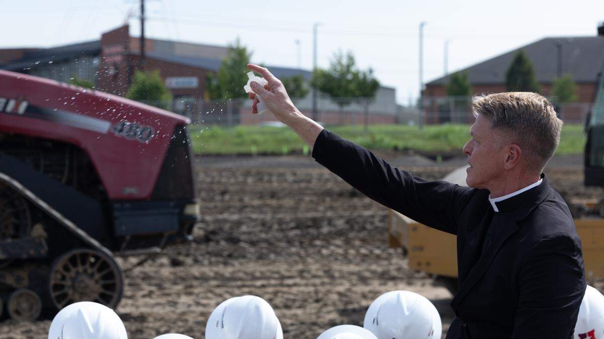 Rev. Jim Deiters, paster of St. Clare Church in O’Fallon, blesses a construction site with holy water during a groundbreaking of a new surgical center and office building by HSHS.
