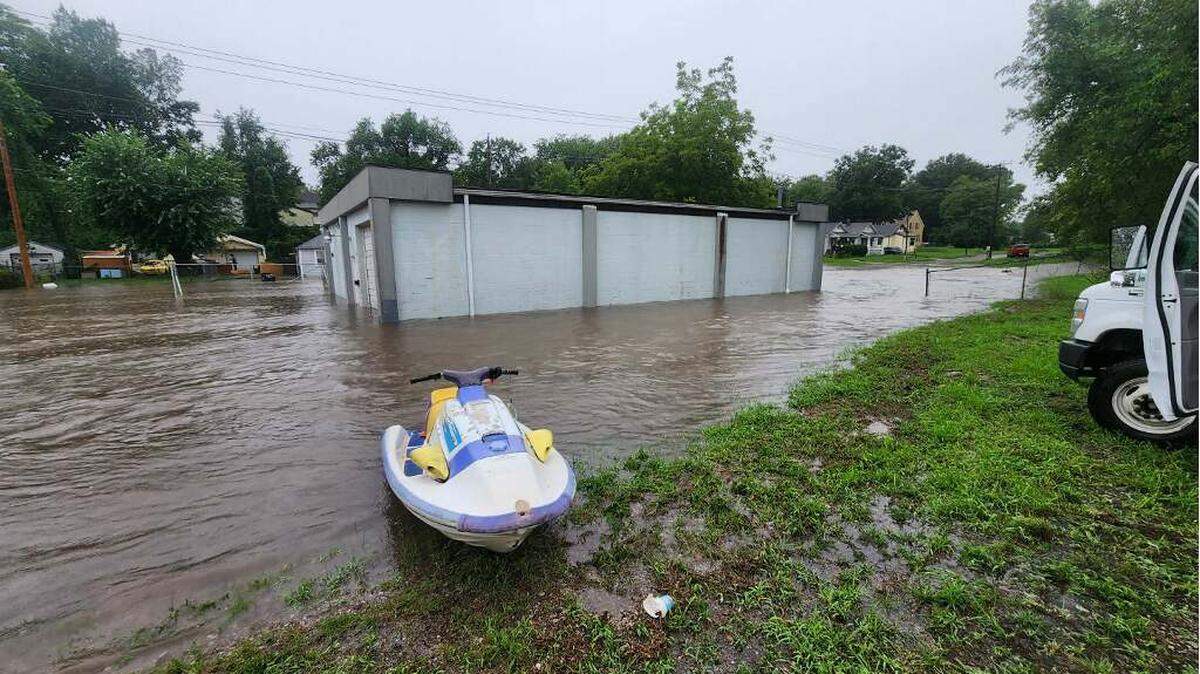 Daniel Green’s jet ski rests on the water in front of his recently purchased property on July 16, 2024. Green tried to stop the water from entering the building, but after it started rising above the creek bank, he gave up and went for a ride.