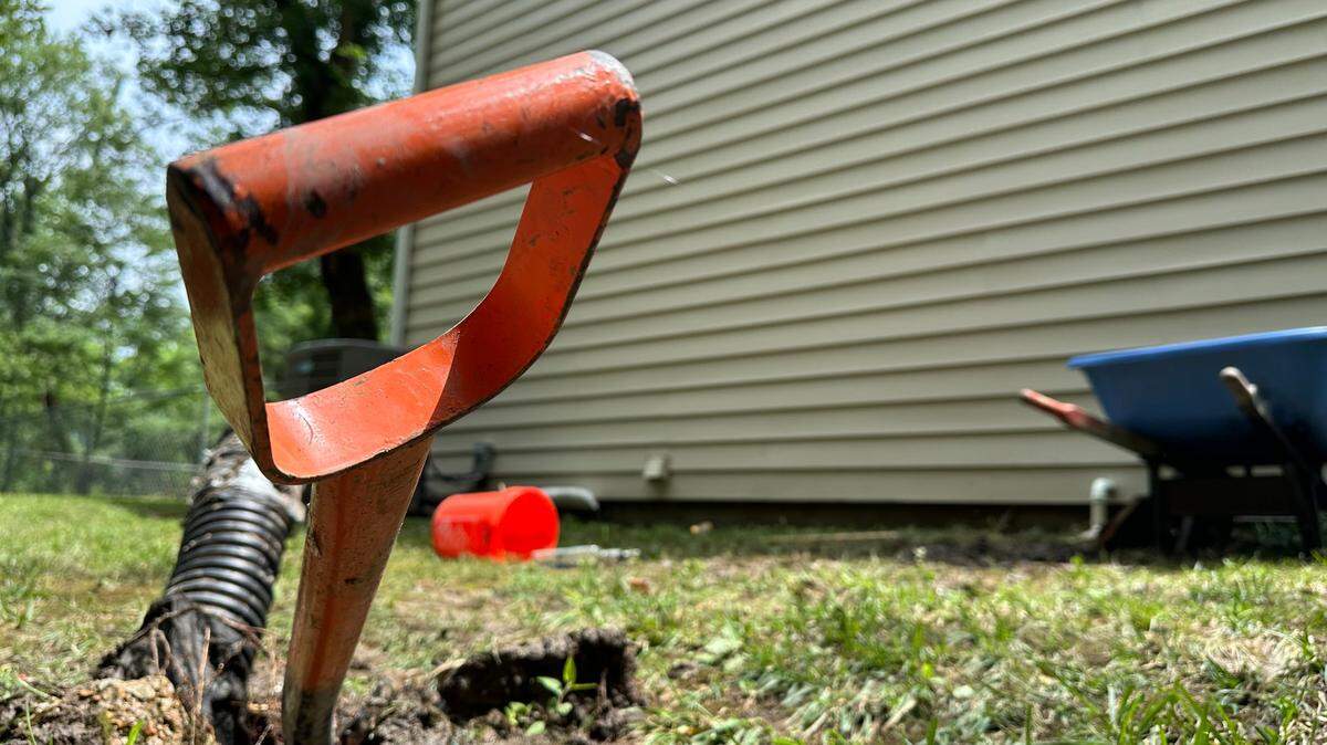 A shovel rests in the wet ground outside of the Bujnak home on July 17, 2024.