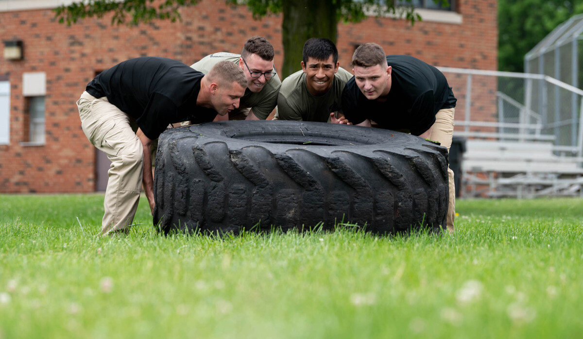U.S. Air Force Airmen from the 375th Air Mobility Wing prepare to flip a tire during an obstacle course at Warrior Park on Scott Air Force Base. These Airmen and other first responders from around Scott and the local community competed against each other in various activities during National Police Week.