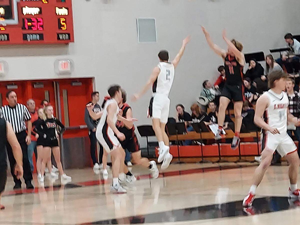 Highland’s Jake Ottensmeier lets fly a 3-pointer over Triad’s Jake Stewart during a Mississippi Valley Conference basketball game Friday at Triad High School. The Bulldogs ultimately posted a 51-43 victory.