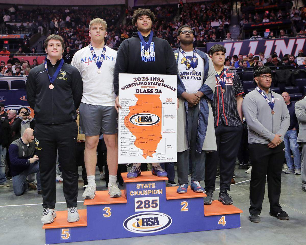Belleville East’s Jonathan Rulo stands atop the podium after winning the Class 3A 285-pound championship championship at the IHSA Individual Wrestling State Finals on Saturday.