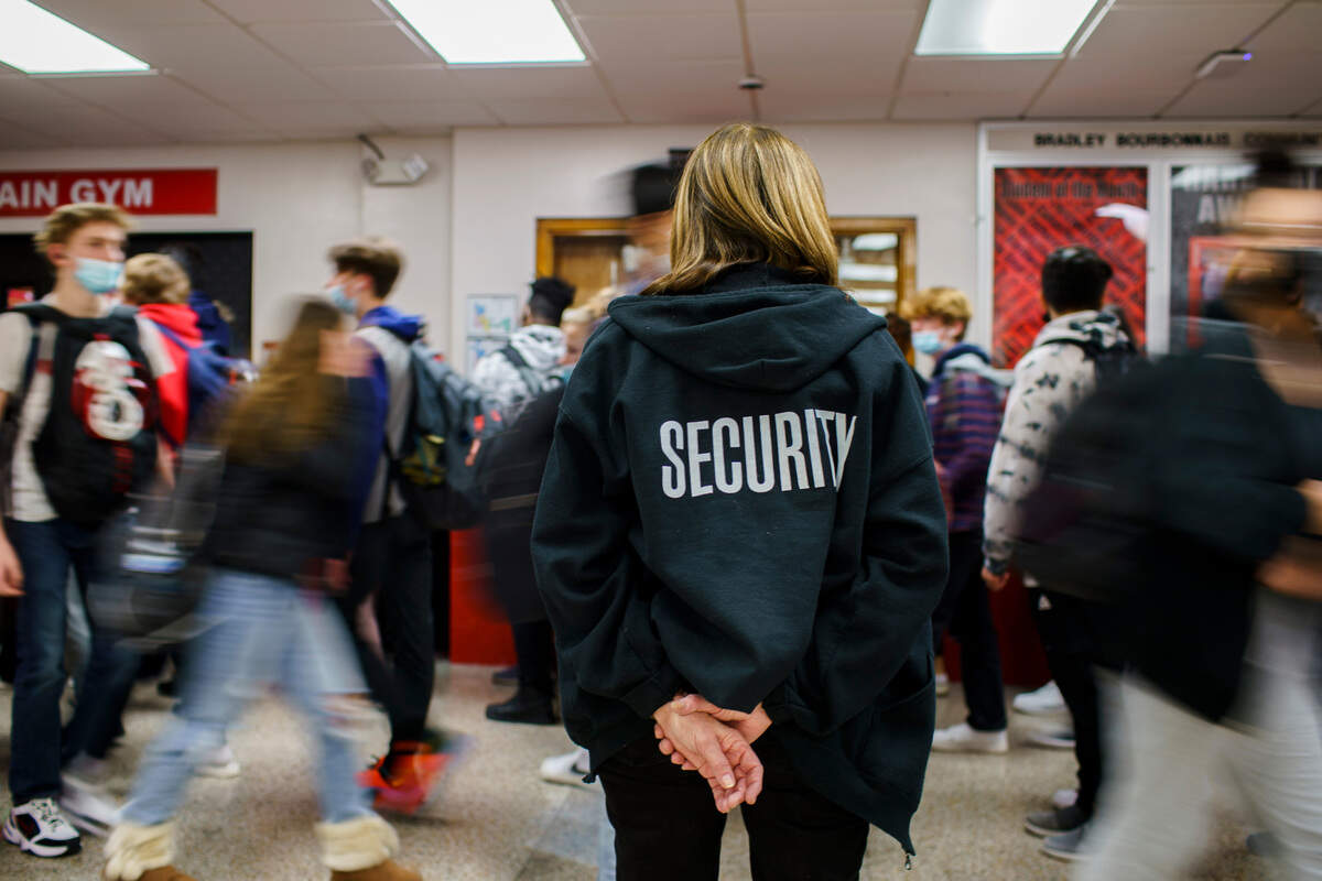 Anita Kanzaki, a member of the Bradley-Bourbonnais Community High School security staff, watches students walk between classes in January.