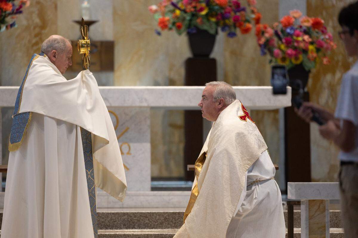Bishop Michael McGovern of the Diocese of Belleville hands off the national traveling monstrance to Bishop Thomas John Paprocki of the Diocese of Springfield during a procession from St. Peter’s and Paul’s Catholic Church to a nearby cemetery of the same name in Collinsville, Ill. on July 8, 2024. The procession is part of a nationwide eucharist pilgrimage, with Catholics traveling from San Francisco to the endpoint of the pilgrimage, Indianapolis, picking up fellow pilgrims along the way.