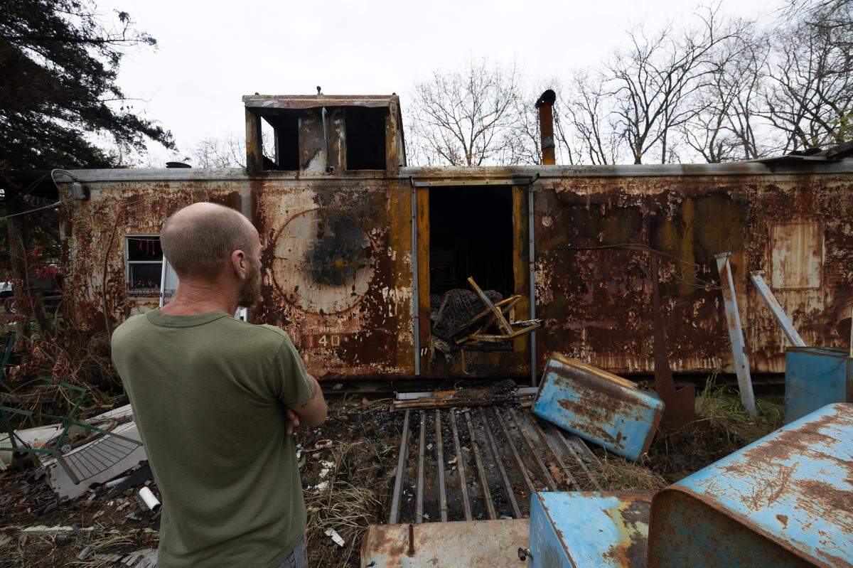 Jason Euge stares back at the caboose where his father died Saturday. His house, an underground building with a sodden roof, sits directly below the caboose. “I was below him in my house when he was burning to death right above me and I didn’t even realize it,” Euge said.