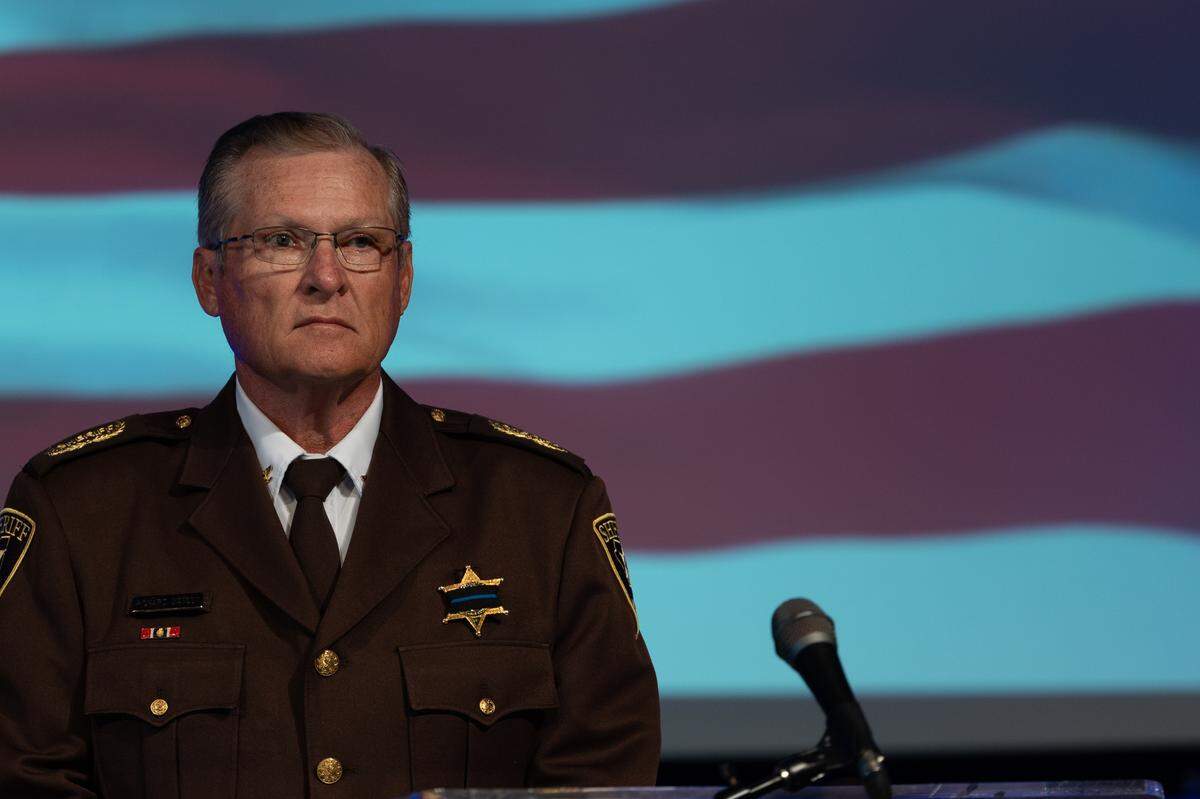 St. Clair County Sheriff Richard Watson stares on while the National Anthem opens a memorial service for fallen police officers of St. Clair County in Christ Church on Frank Scott Parkway in Fairview Heights, Ill. on May 7, 2024.