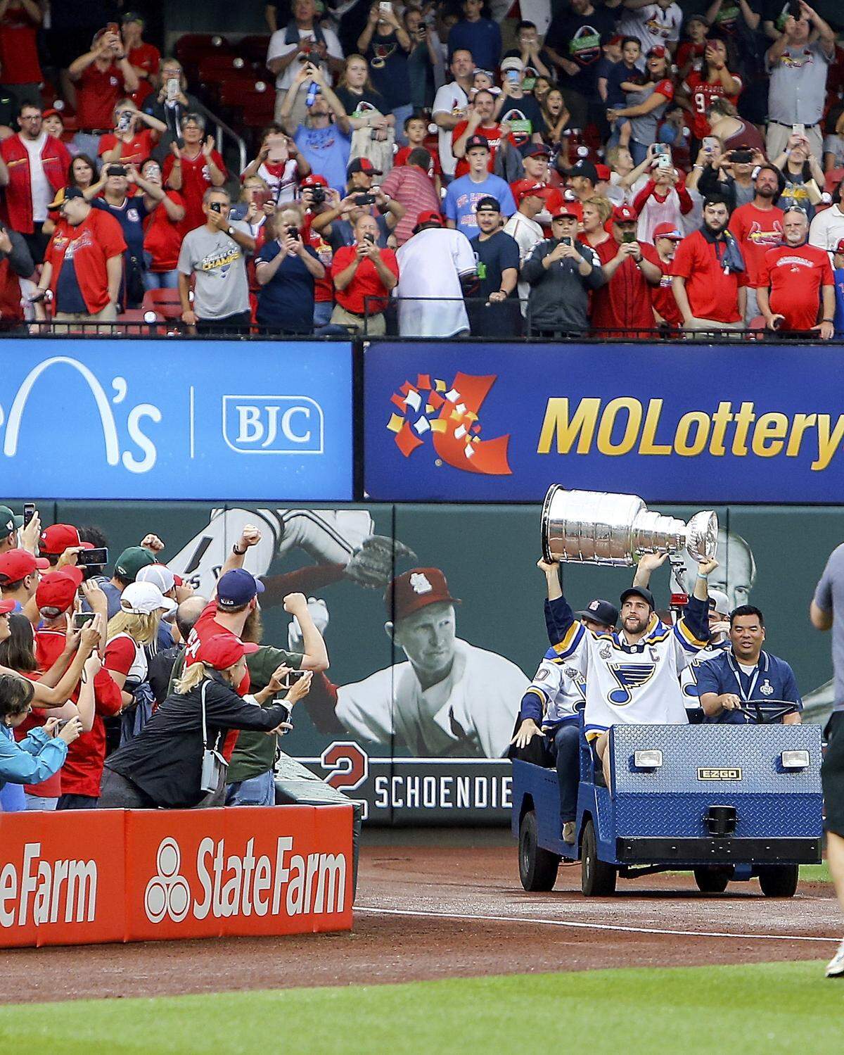St. Louis Blues’ Alex Pietrangelo holds the Stanley Cup overhead as he makes his way around the warning track during a ceremony honoring the St. Louis Blues Stanley Cup victory prior to the the start of a baseball game between the St. Louis Cardinals and the Oakland Athletics Wednesday, June 26, 2019, in St. Louis. (AP Photo/Scott Kane)