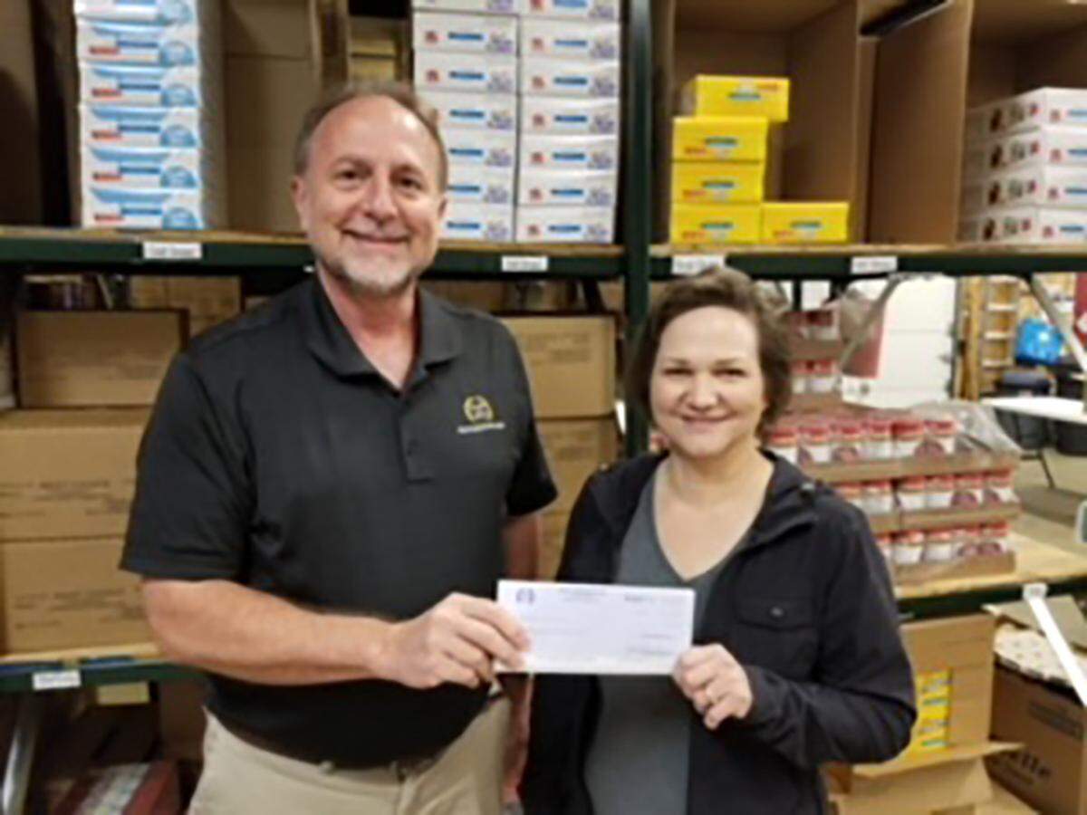 Top Ag Cooperative CEO Kevin Hartkemeyer distributed $9,000 to area foodbanks in August. The Highland Area Christian Service Ministry in Highland, the Green Bean Food Pantry in Trenton and the Washington County Food Pantry Irvington were the chosen recipients of $3,000 each. Top Ag along with its business partners CoBank and Land O’Lakes who provided matching grants of $1,000 each to each of the three organizations.  Pictured: Diane Williams from The Highland Area Christian Service Ministry receives a check for $3,000 from Kevin Hartkemeyer.