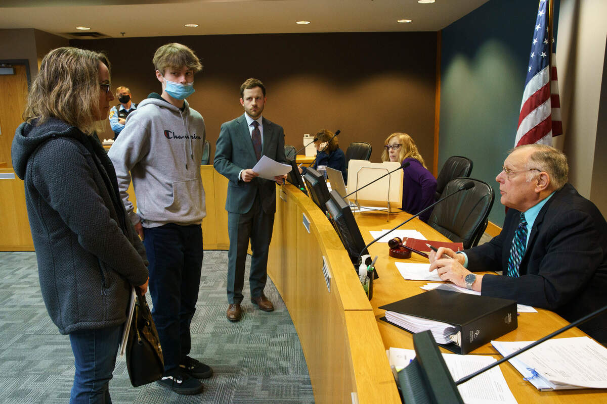Michele Nepras and her son Nathan, 16, talk with McHenry city prosecutor Michael Fioretti, center, and adjudication hearing officer Harry H. Semrow Jr. in March.