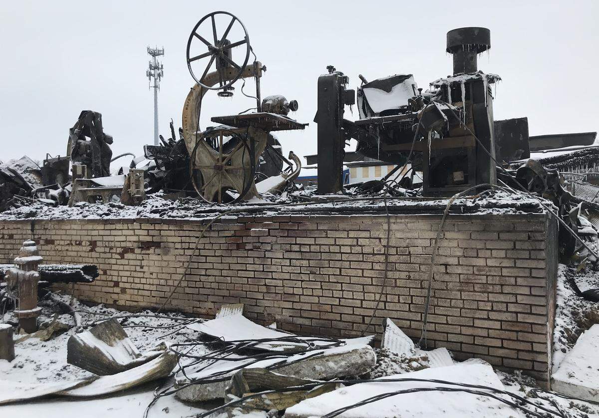 Snow covers a mangled mess of burned equipment and millwork products in an outbuilding of R.P. Lumber Co. in Edwardsville after a fire on Monday. The cause is being investigated.