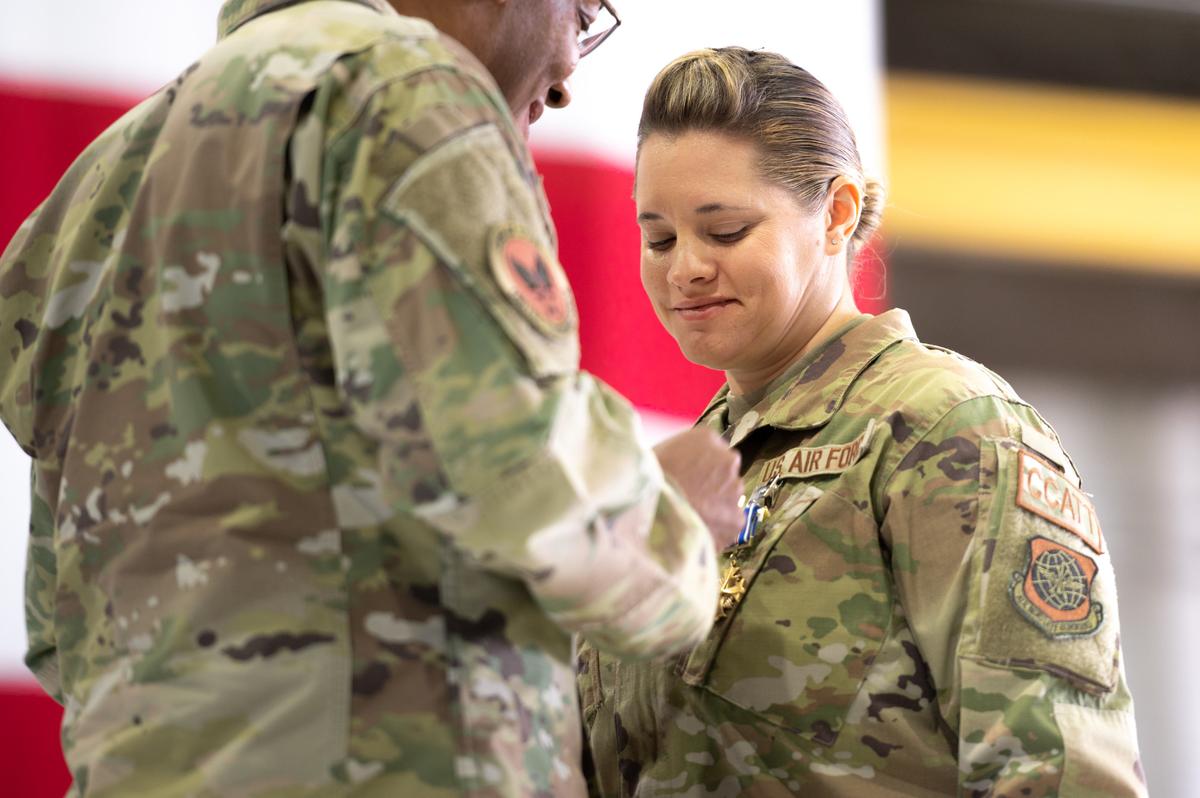 U.S Air Force Chief of Staff Gen. CQ Brown, Jr. pins the Distinguished Flying Cross on Tech. Sgt. Katherine Rosa Orellana, 375th Medical Group critical care and trauma team respiratory therapist, on Scott Air Force Base for her heroic efforts during Operation Allies Refuge. During Operation Allies Refuge, Airmen banded together to evacuate approximately 124,000 American citizens and Afghan evacuees.