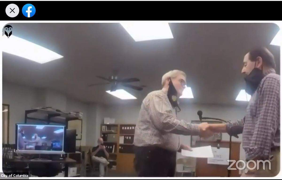 Columbia City Clerk Wesley Hoeffkin, left, is shown shaking hands with former Ward 3 Alderman Gene Ebersohl after swearing him in as acting mayor on Wednesday night at a special meeting streamed live on Facebook.