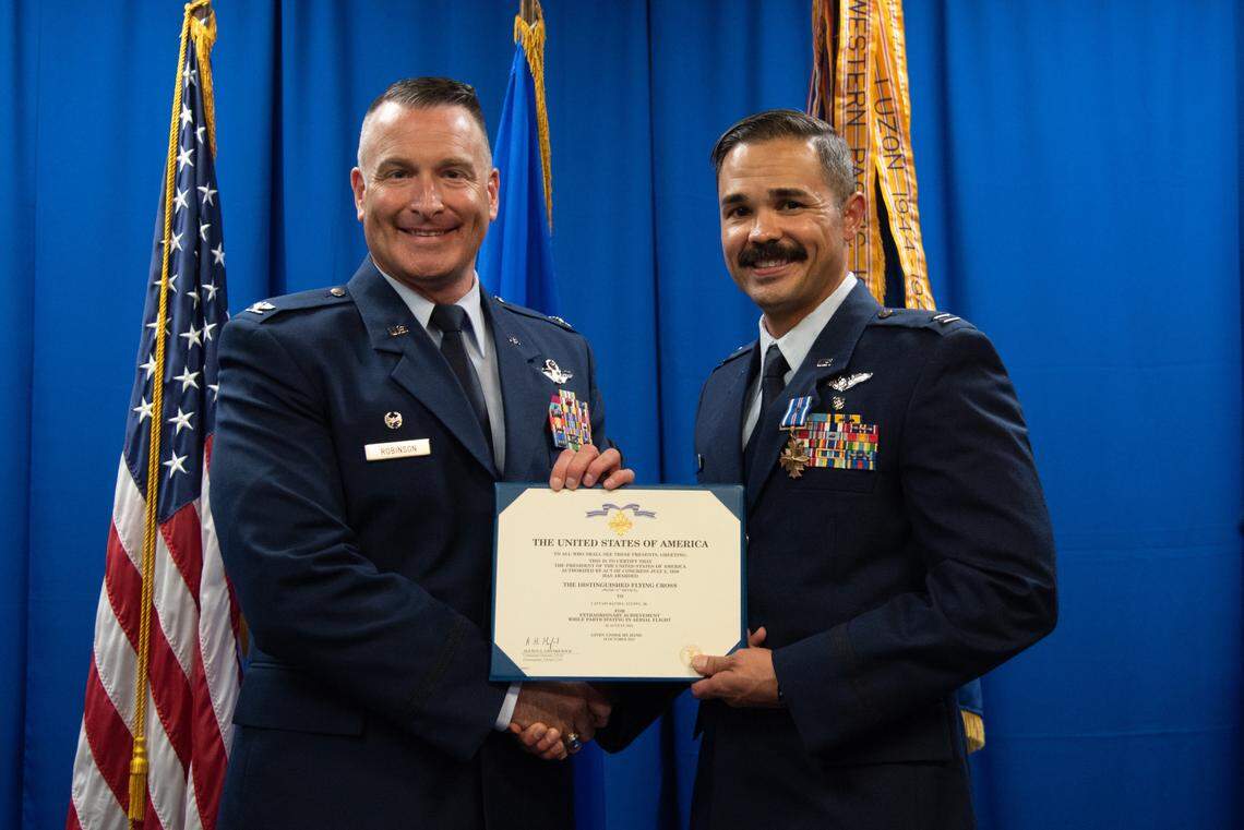 U.S Air Force Col. Chris Robinson 375th Air Mobility Wing commander, presents citation to Capt. David Stuppy Jr., 375th Aeromedical Evacuation Squadron flight nurse, on Scott Air Force Base. The Distinguished Flying Cross is a prestigious military decoration awarded to individuals who display exceptional bravery and heroism during aerial operations.