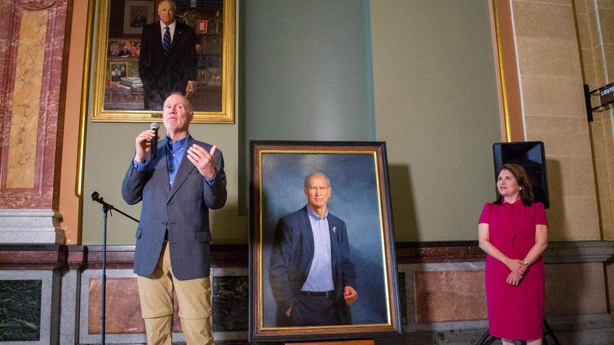 Former Gov. Bruce Rauner, now a Florida resident, unveils his official portrait before it is hung on the wall of the Illinois State Capitol. Rauner, a Republican, was governor from 2015 until 2019. Pictured above Rauner is the portrait of his predecessor, Democrat Pat Quinn, and at right is his Lt. Gov. Evelyn Sanguinetti.