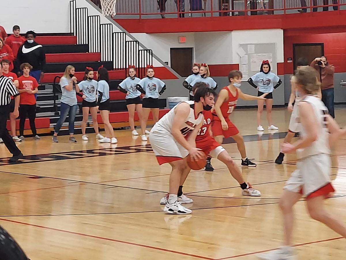 Highland’s Joe Jansen holds the ball looking for a cutter to pass to while being guarded by Triad’s McGrady Noyes during the Bulldogs 55-54 Mississippi Valley Conference victory Friday, Dec. 17, at Highland High School.