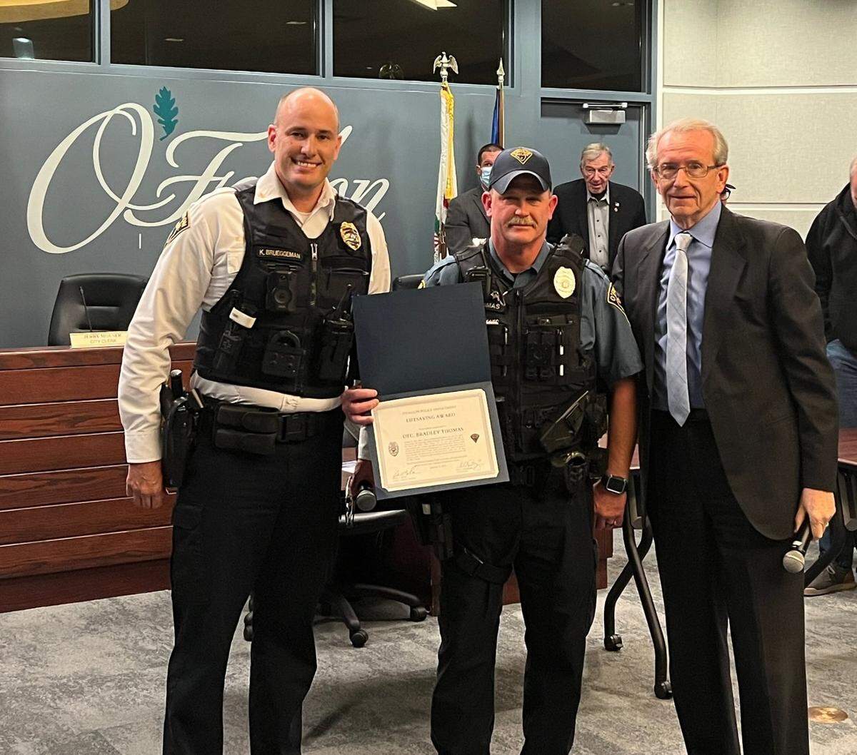 O’Fallon Police Department Officer Brad Thomas, center, received the Lifesaving Award at the Jan. 18 O’Fallon City Council meeting stemming from his heroic actions Oct. 21. Thomas performed chest compressions for over four minutes on a man until other personnel arrived, helping save his life. At left is Police Chief Kirk Brueggemann and at right is Mayor Herb Roach.