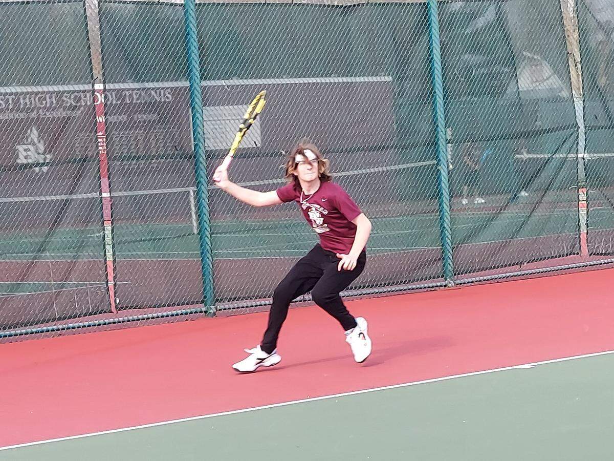 Belleville West’s Jerry Aplin returns a shot during a nonconference tennis match against Highland on Monday, March 27, at Belleville West High School. HHS started and finished strong in rolling to an 8-1 match win over the Maroons.