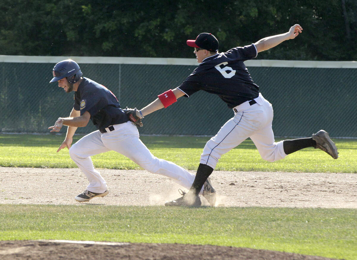 Highland shortstop Jonathan Dickman tags out Alton’s Elijah Dannenbrink during a rundown in Post 439’s game on Wednesday with Post 126.