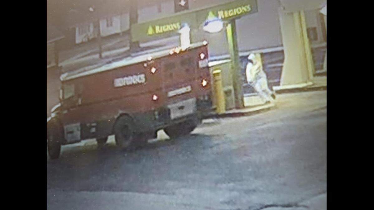 A surveillance photo released by the FBI shows a suspect in white clothing during an armed robbery of Brink’s armored vehicle drivers Thursday morning at the Regions Bank in Madison.