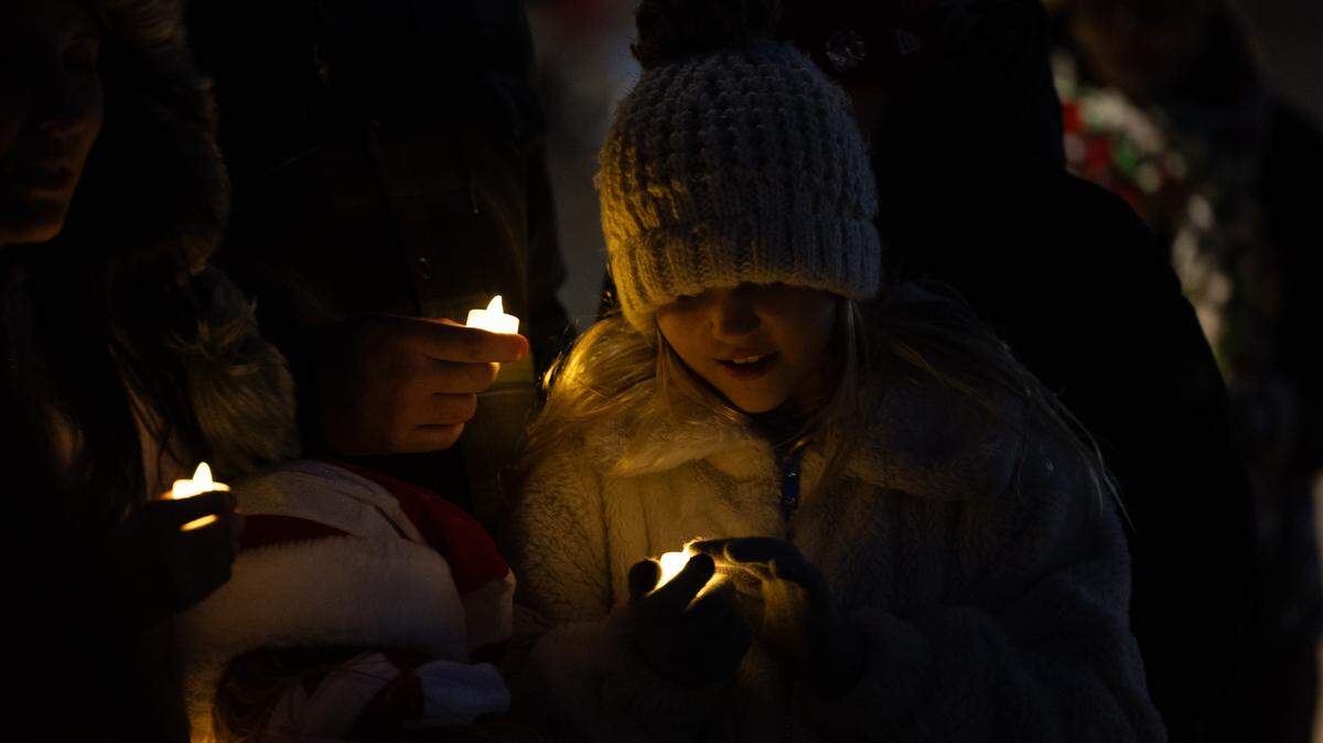 Members of the Musick family light electric candles during the candlelight vigil for those who lost.