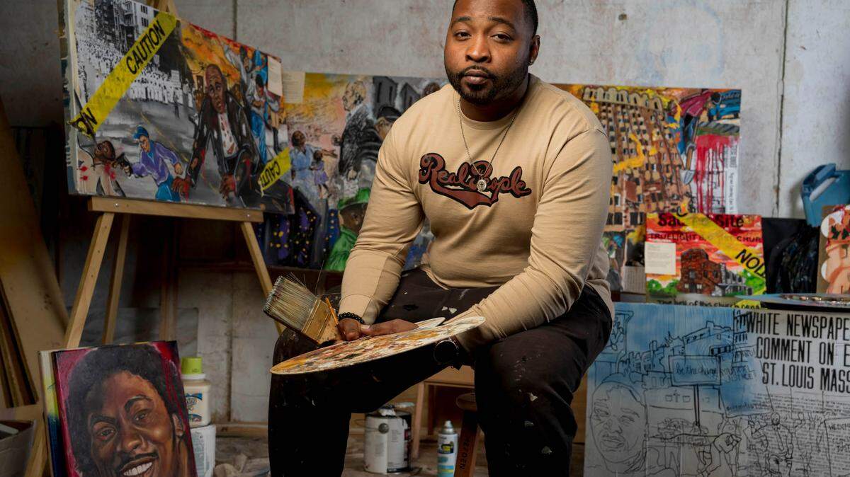 Mykael Ash sits in his studio in East St. Louis, Illinois. Ash uses bullet shells he finds on the ground as elements in his artwork to tell stories about racial violence, resistance, and history. (Whitney Curtis for KHN)
