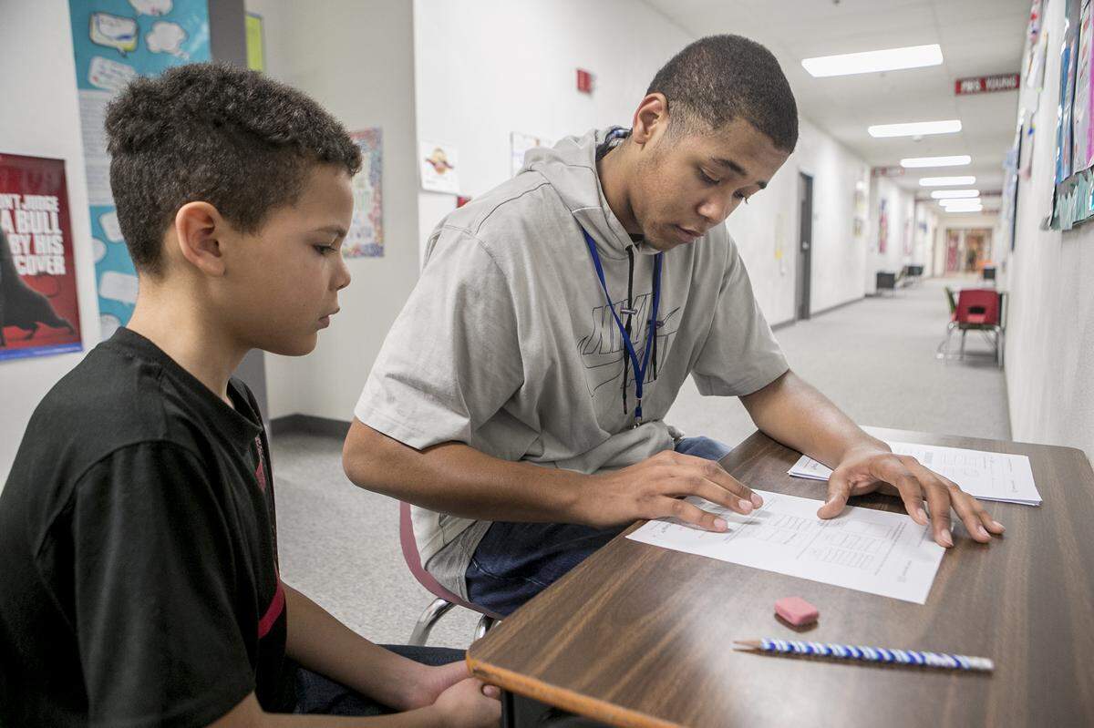 Third grade student Tyrell Charles and Sparta High School senior Jonah Boston work on fractions. High school students in Sparta work with elementary students to gain work experience and see if they might enjoy a teaching career.