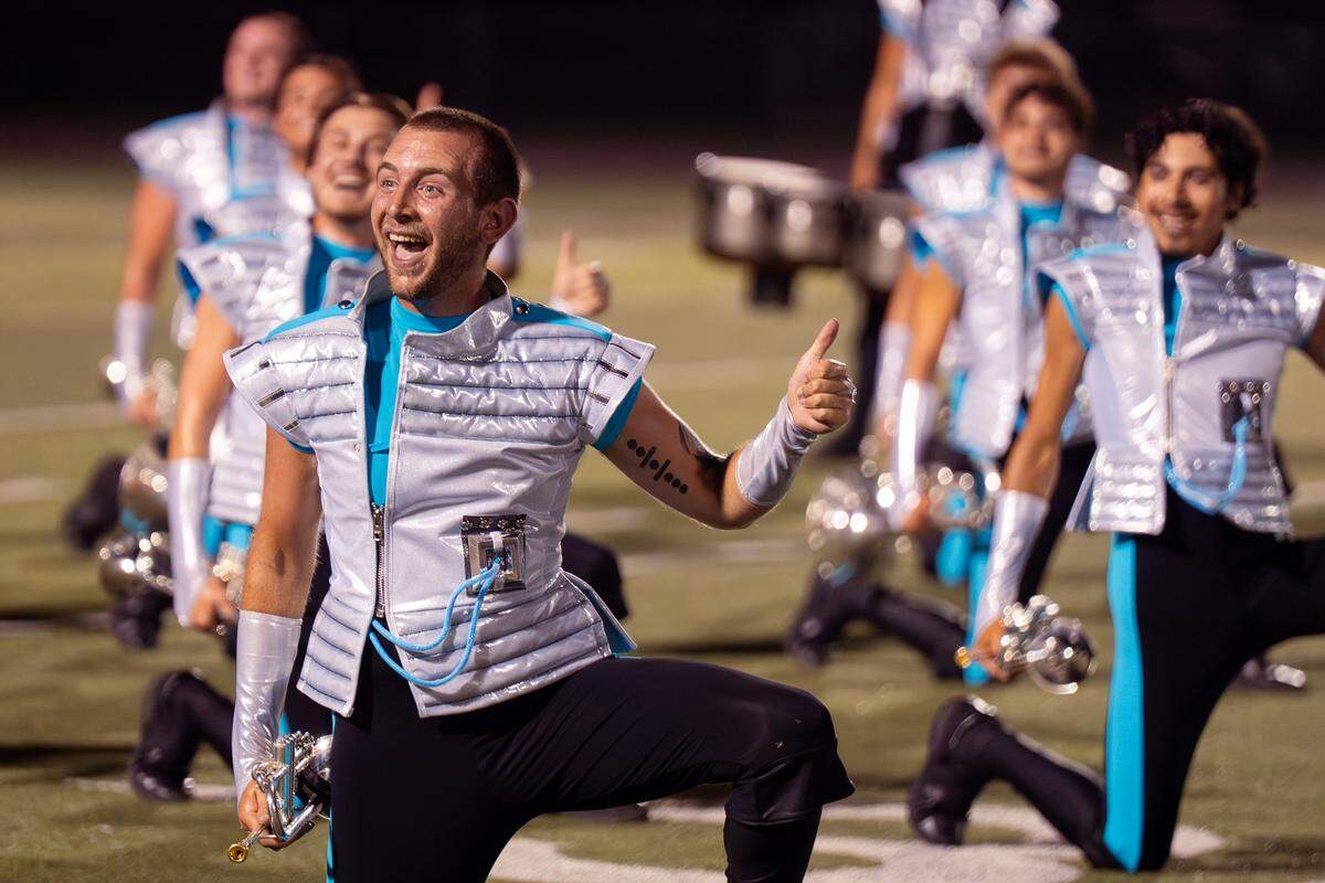 Hunter Jones, 21, a trumpet player from Johnson City, Tennessee, gives a thumbs up during The Boston Crusaders’ performance of their show “BOOM” at Belleville West High School on Tuesday, July 22, 2025, in Belleville.