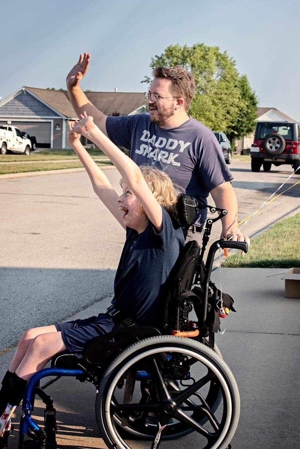 Airomise Herman and his father, Josh Herman, wave as a parade of an estimated 100 Jeeps rolled by his O’Fallon home to wish him a happy 14th birthday.