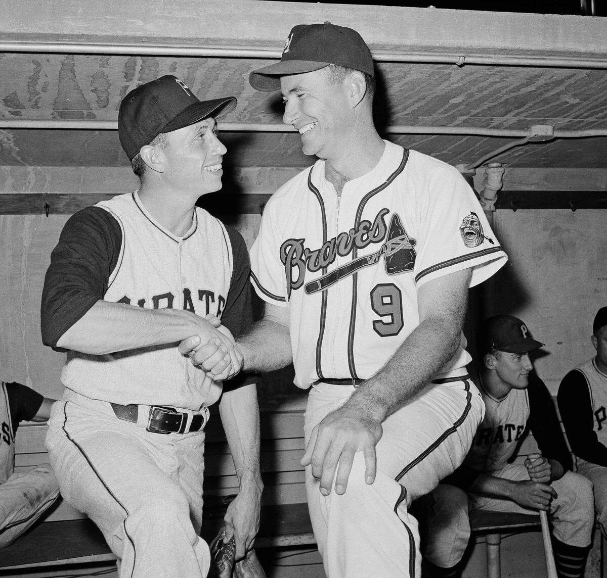 Harvey Haddix of the Pittsburgh Pirates, left, and Joe Adcock of the Milwaukee Braves, shake hands in the dugout prior to the start of another Pirates-Braves contest in Milwaukee, May 27, 1959. Adcock’s hit in the 13th inning spoiled a perfect game for Haddix with a 1-0 victory for Milwaukee. Haddix will receive a special honorary award from the National League for his history-making pitching performance. (AP Photo/Dwayne Newton)