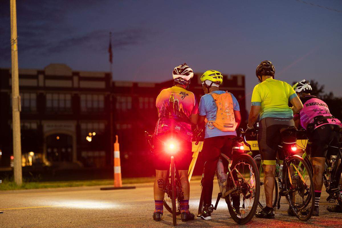 Members of the Regulators Cycling Club group up after the final “sunset tour” of the Tour de Belleville bike ride event on July 12, 2024.
