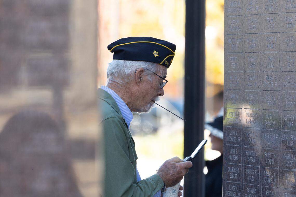 A veteran takes a photo of the memorial wall in Belleville’s Public Square during Belleville’s 26th annual Veterans Day ceremony on Nov. 11, 2024.