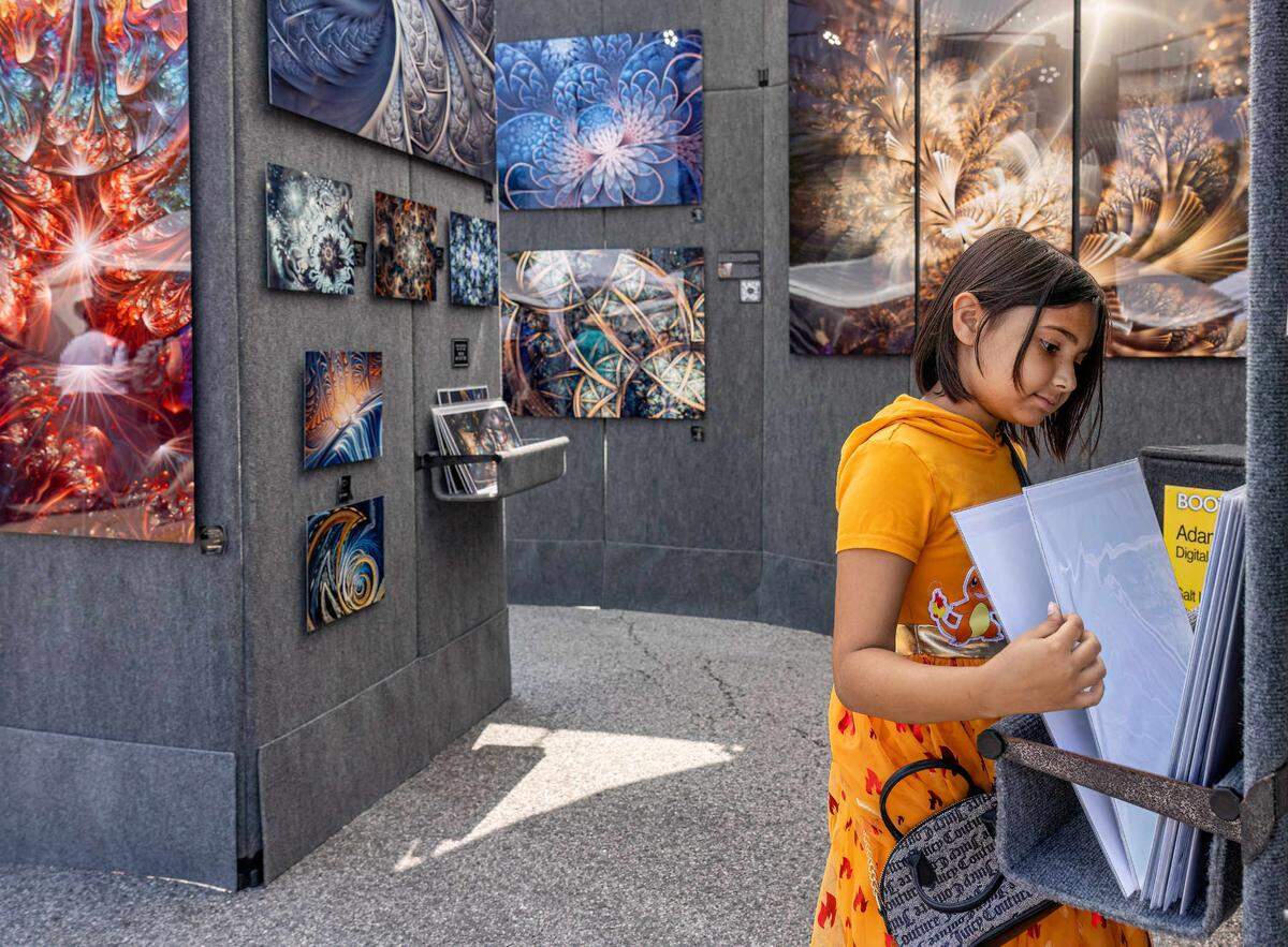 Melody Land of Belleville looks through the Art Gallery of Adam Hoffman at the Art on the Square show Saturday.